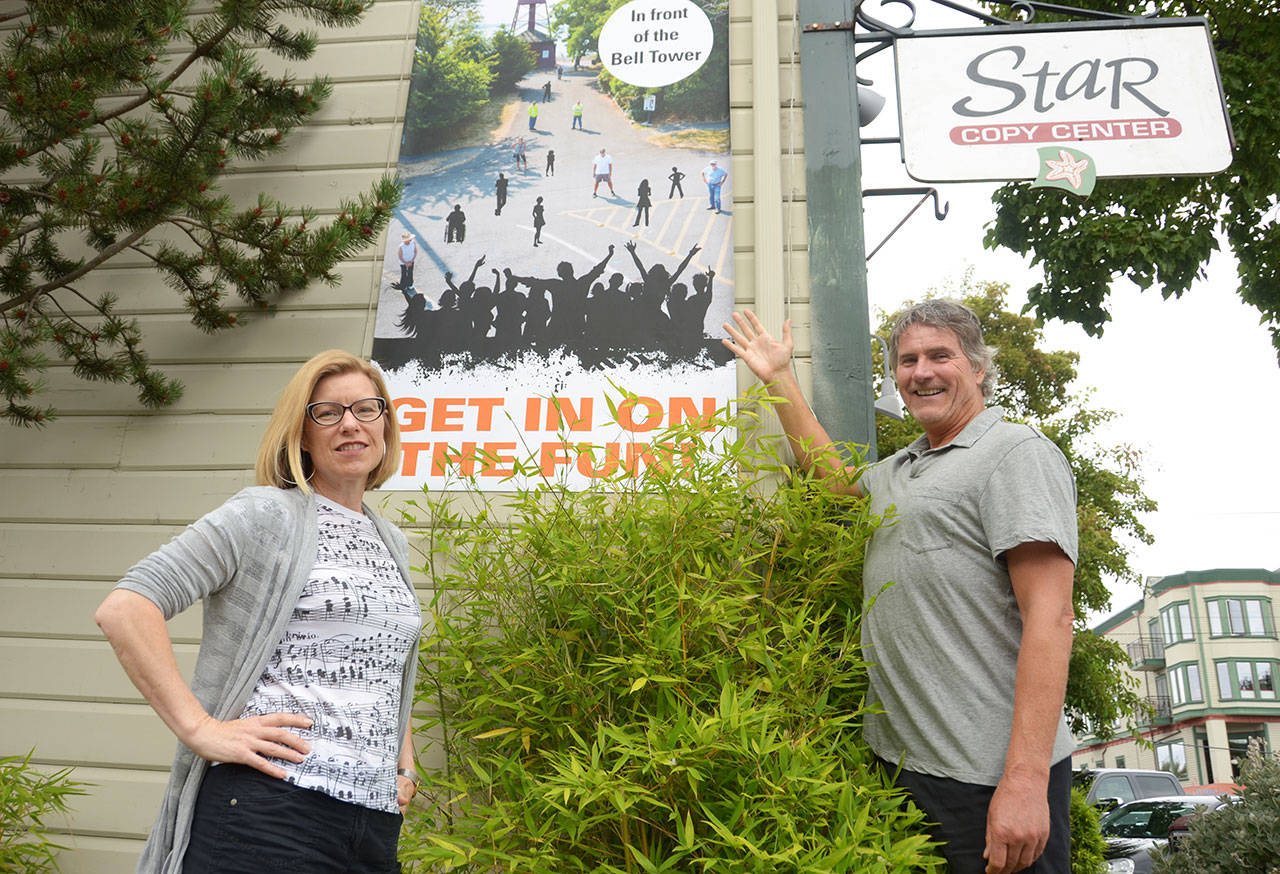 Polly Macomber, a Port Townsend-based graphic designer, and Mike Kenna, owner of Pintery Communications in uptown, are two of the people putting together this year’s town portrait which will feature the historic bell tower in uptown Port Townsend. (Cydney McFarland/Peninsula Daily News)