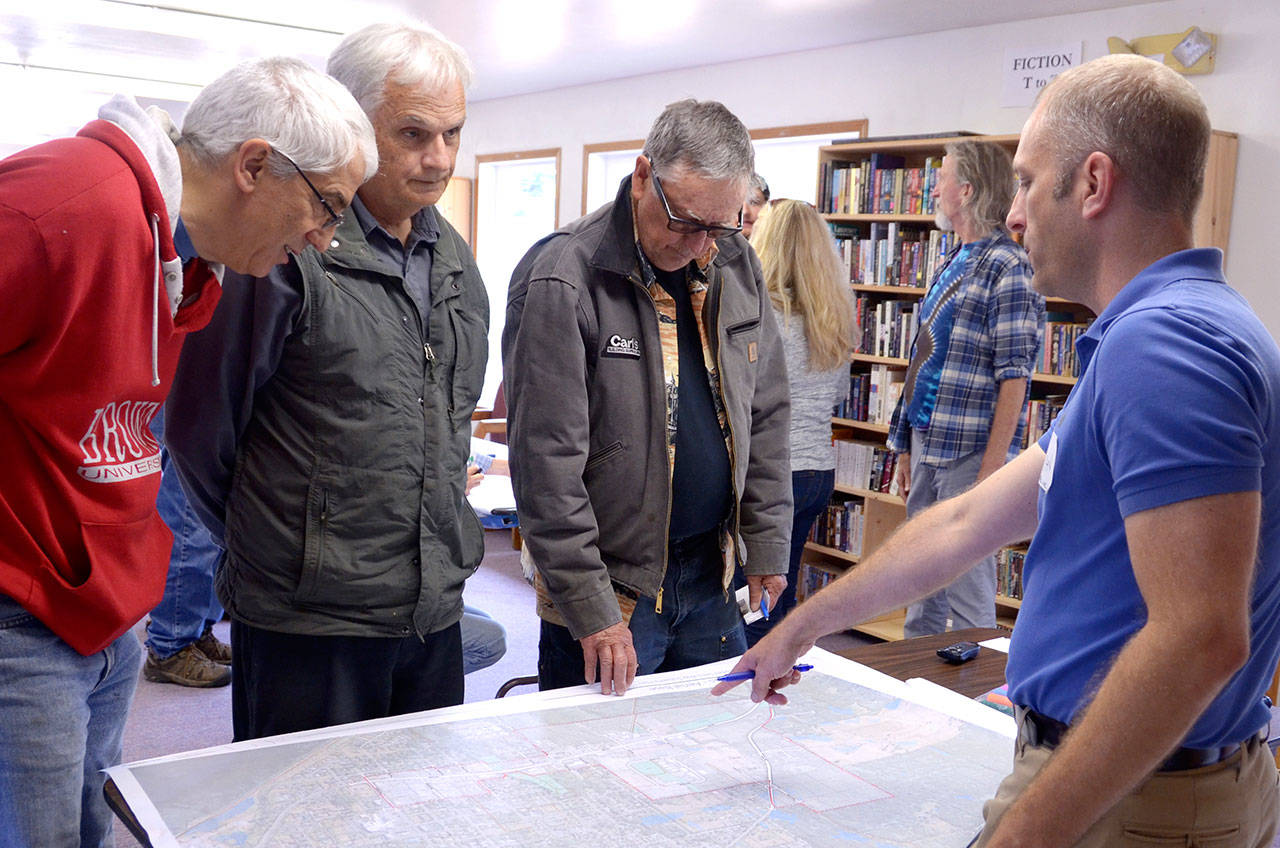 Ryan Givens, right, a project manager from AHBL, a Seattle-based engineering consultant, discussed the options for the Howard Street and Upper Sims Way subarea project with community members at an open house Wednesday. (Cydney McFarland/Peninsula Daily News)