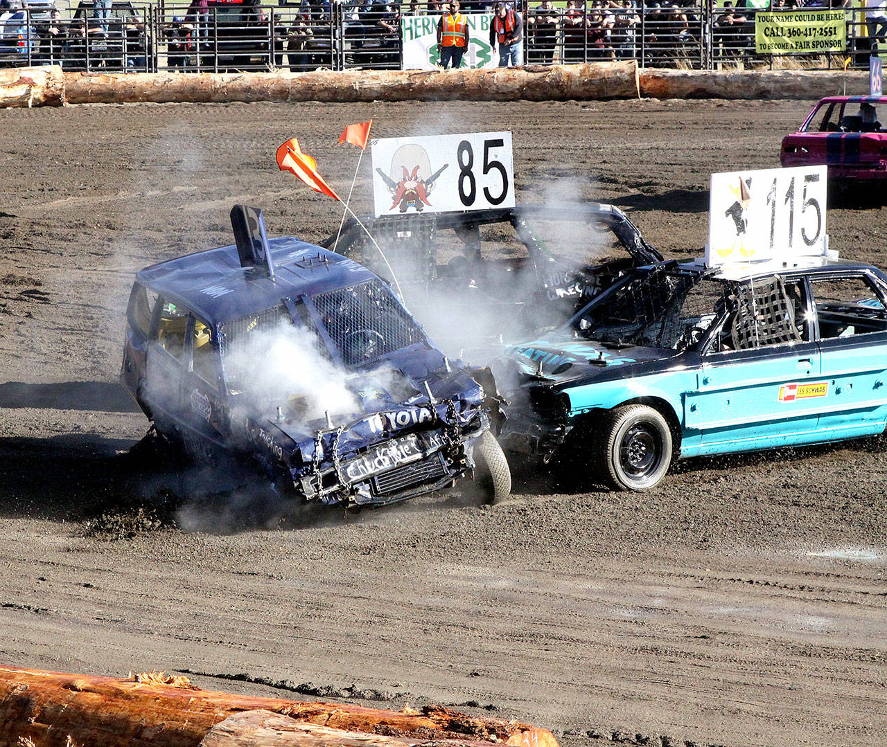 No. 115 Dylan Pieze and No. 85 Zach Bratcher put a big hit on No. 13 Ryan Michaeu of Forks in the demolition derby Sunday evening at the Clallam County Fair. It was a full house with 1,600 tickets sold for the event. (Dave Logan/for Peninsula Daily News)