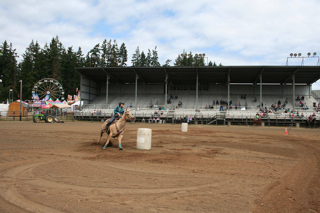 Emma Albright and Tinkerbell compete in barrel racing during the Clallam County Fair’s 4-H games show. They finished with a fastest time of 16.357 seconds. (Karen Griffiths/for Peninsula Daily News)
