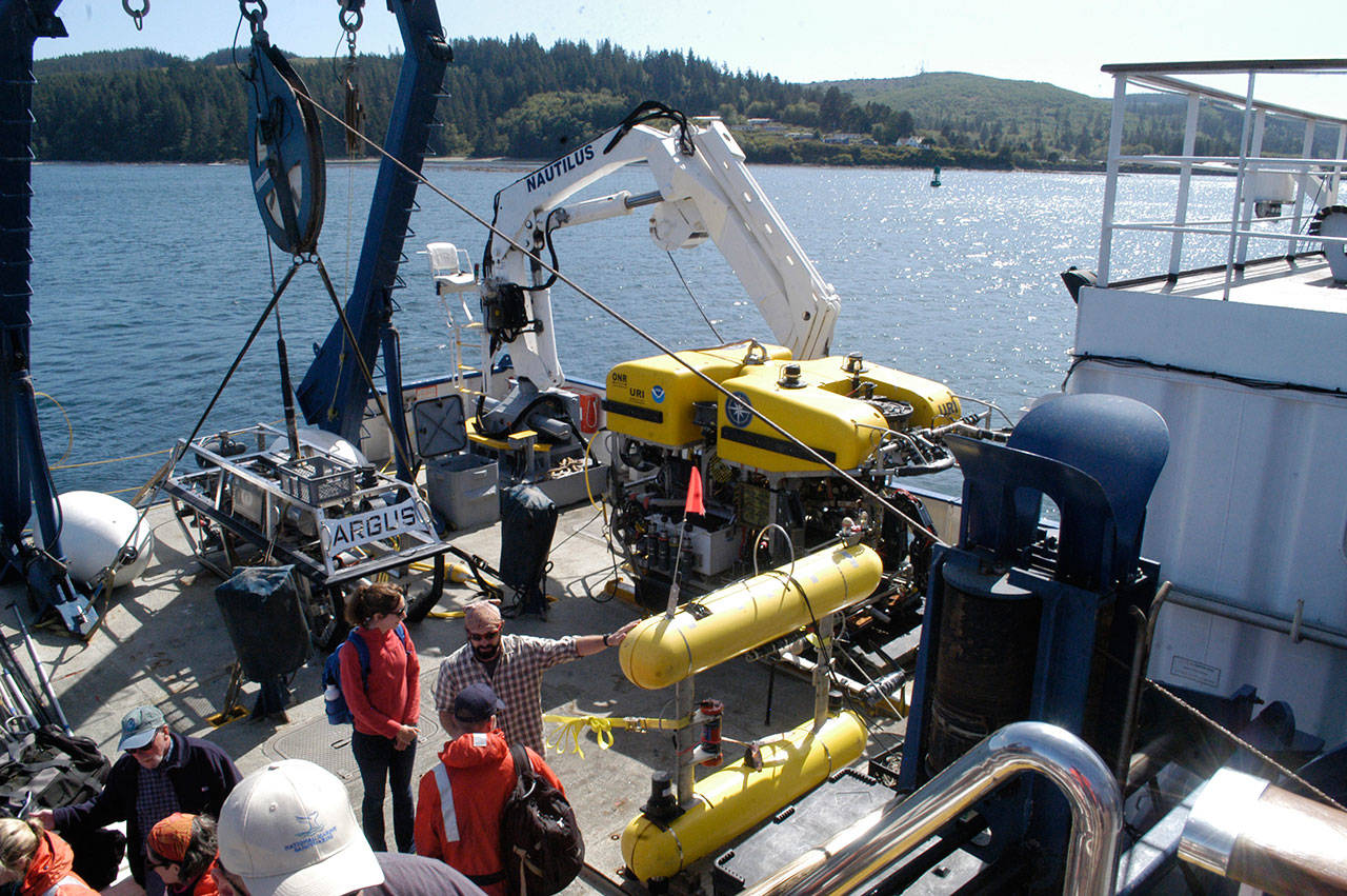 Scientists gather at the stern of the EV Nautilus near the ROVs Argus, center, and Hercules, right. (Rob Ollikainen/Peninsula Daily News)