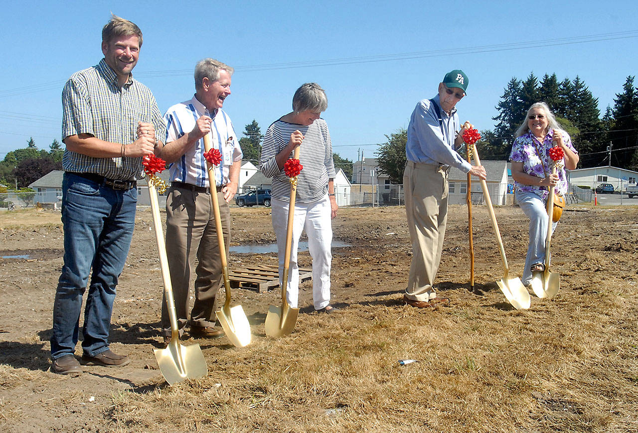 Faced with the prospect of digging into rock-hard soil, Sea Ridge public housing development groundbreakers crack jokes about the ineffectiveness of their shovels during a ceremony Tuesday at the Mount Angeles View development in Port Angeles. Wielding shovels are, from left, state Rep. Mike Chapman, Clallam County Commissioner Randy Johnson, Peninsula Housing Authority board member Norma Turner, Port Angeles Mayor Patrick Downie and housing authority Vice Chair Pat Teal. (Keith Thorpe/Peninsula Daily News)