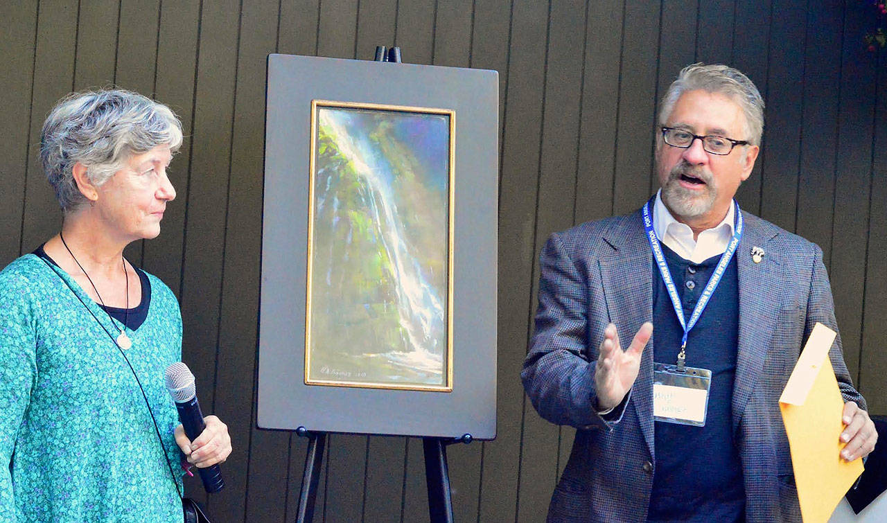 Paint the Peninsula judge Cathe Gill listens as Best in Show winner Bruce Gomez describes painting Olympic National Park’s Madison Falls. Gomez was among the artists who won awards totaling $12,000 on Aug. 26 at the Port Angeles Fine Arts Center. (Diane Urbani de la Paz)