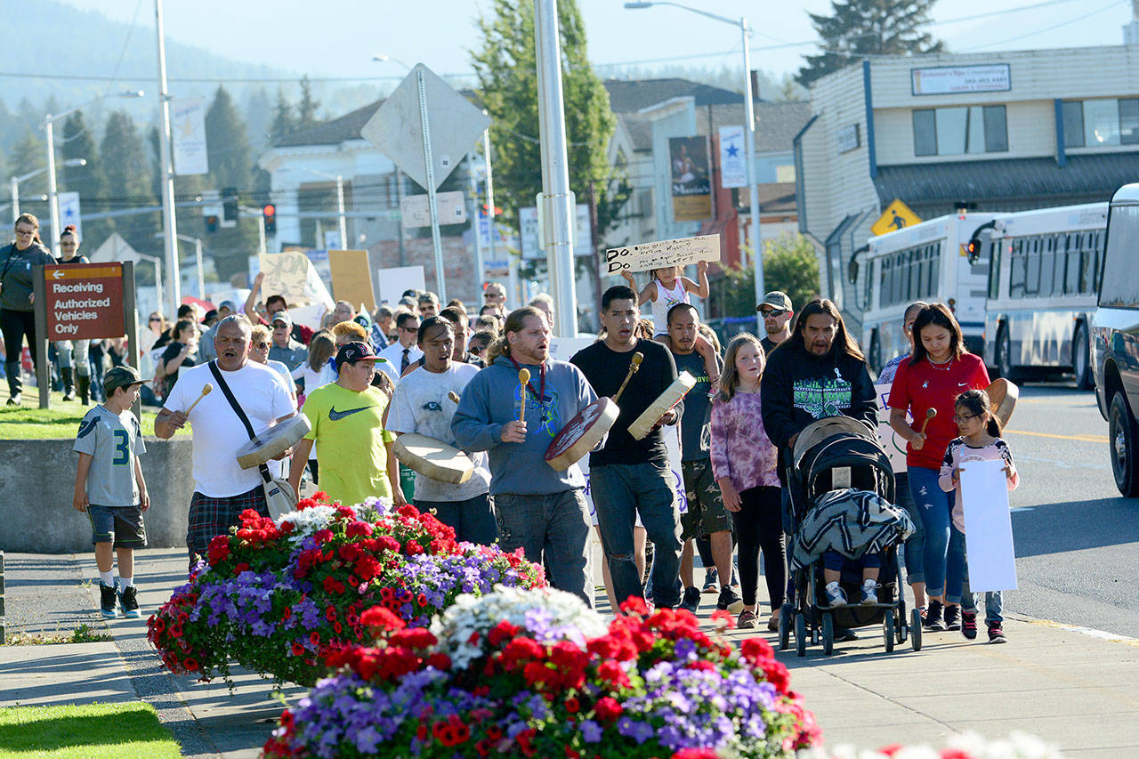 Lower Elwha Klallam Tribal members drum and sing as a crowd walks down Lincoln Street in Port Angeles on Thursday for International Overdose Awareness Day. (Jesse Major/Peninsula Daily News)