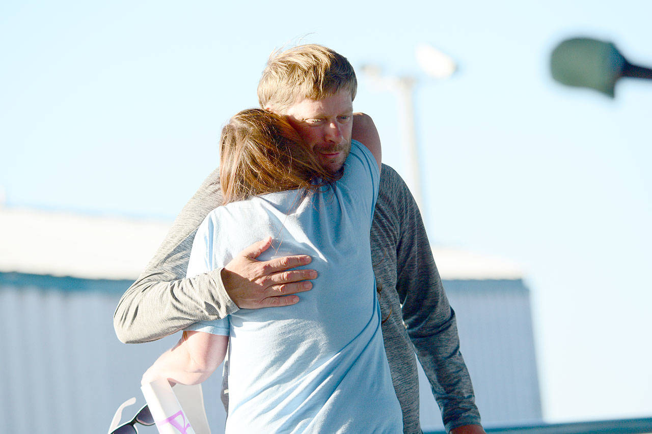 State Rep. Mike Chapman, D-Port Angeles, hugs Monica Farris, who spoke about her recovery Thursday during International Overdose Awareness Day activities in Port Angeles. (Jesse Major/Peninsula Daily News)