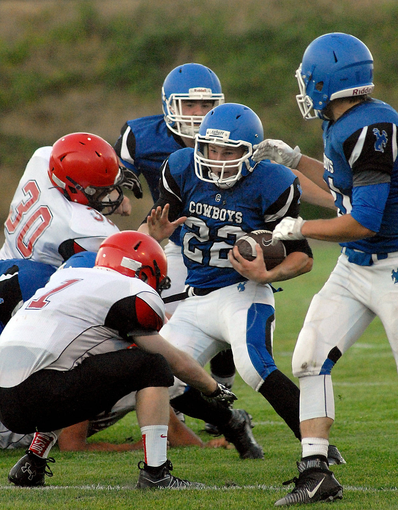 Chimacum&rsquo;s Logan Shaw (22) tries to elude the defense of Neah Bay&rsquo;s Daniel Kilmer (30), left, and Meric Soeneke (1) after receiving blocking assistance from teammates Ryan Caldwell (55), back, and Matthew Bainbridge (31), right, in the first quarter of Chimacum&rsquo;s 21-6 victory.                                Keith Thorpe/Peninsula Daily News