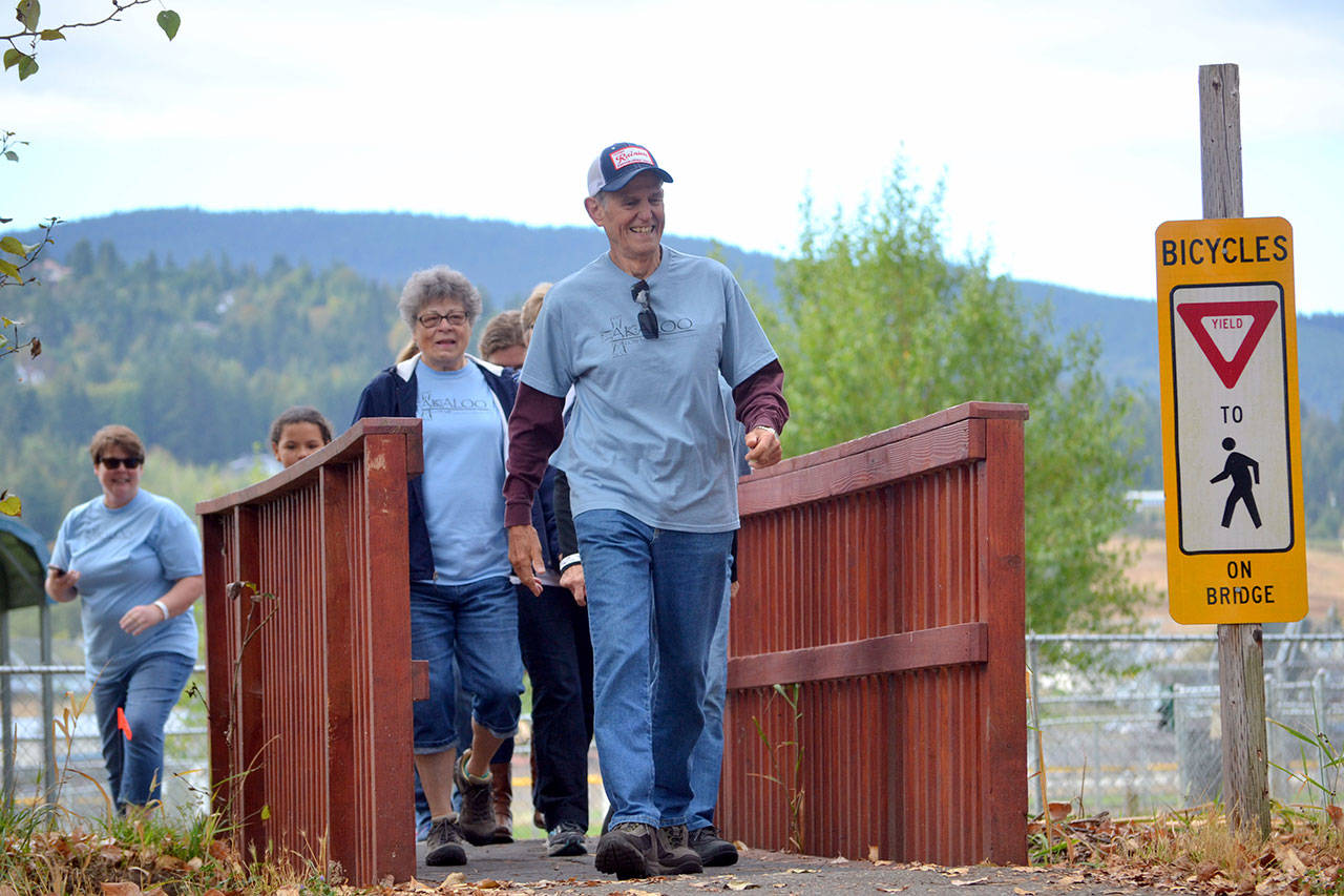 Paul Wessel of Sequim walks over a bridge in Carrie Blake Park as part of the Fun Walk benefiting the Dungeness Valley Health Wellness Clinic last year. (Matthew Nash/Olympic Peninsula News Group)