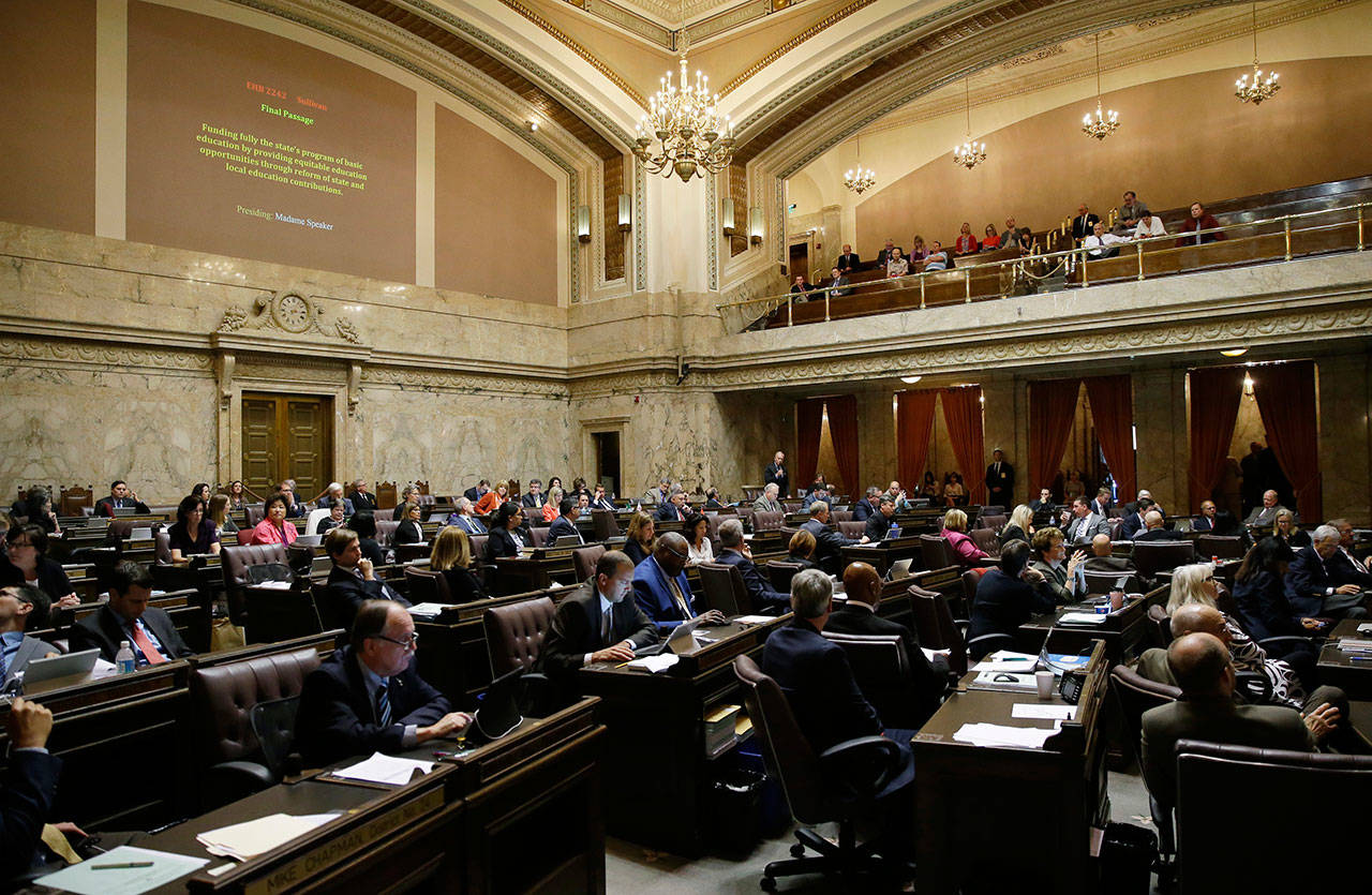 Representatives work on the House floor in June during discussion of a bill to fully fund education in Washington state at the Capitol in Olympia. (Ted S. Warren/The Associated Press)