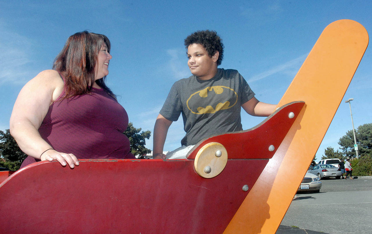 Tiffany Sudela-Junker of Port Angeles speaks with her son, Jonah Junker, 13, on the playground at Port Angeles City Pier. Sudela-Junker was recognized for her advocacy work for providing care for children with traumatic childhood experiences. (Keith Thorpe/Peninsula Daily News)