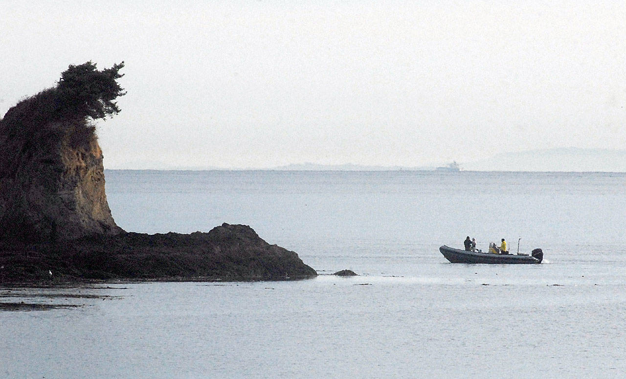 A support boat carrying swimmer Melissa Blaustein of San Francisco approaches the rocky shore at Observatory Point along Freshwater Bay west of Port Angeles prior to her attempt to swim across the Strait of Juan de Fuca on Saturday. (Keith Thorpe/Peninsula Daily News)