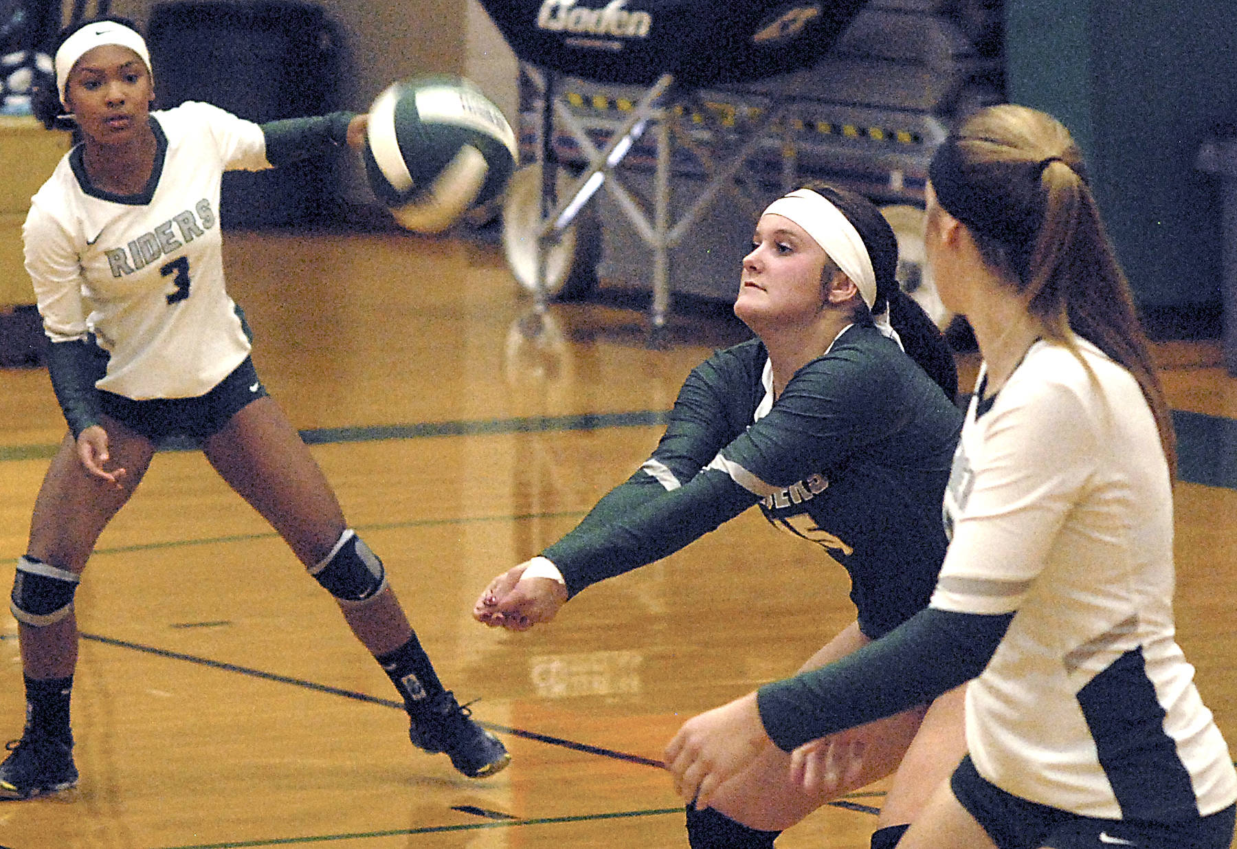 Keith Thorpe/Peninsula Daily News                                Port Angeles’ Brennan Gray, center, sets the ball as teammates Lannie Lyamba, left, and Devin Edwards look on in the second game of Tuesday night’s match against Bremerton at Port Angeles High School.