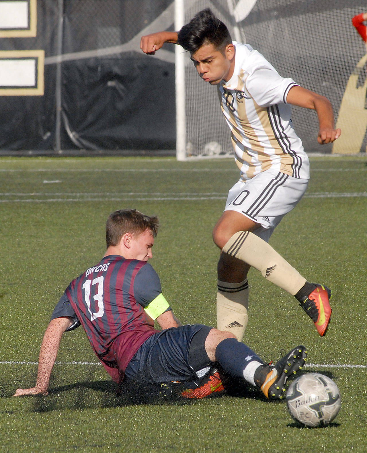 Peninsula’s Cesar Gervacio. right, tries to avoid the tackle from Whatcom’s Eric Jones in first-half play on Wednesday in Port Angeles.                                Keith Thorpe/Peninsula Daily News
