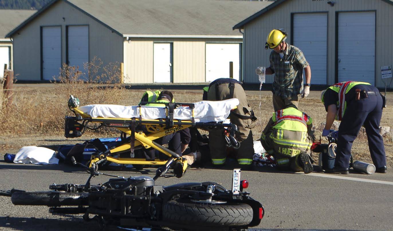 Emergency responders tend to a motorcyclist who sustained leg injuries in a wreck in Sequim on Tuesday. (Erin Hawkins/Olympic Peninsula News Group)