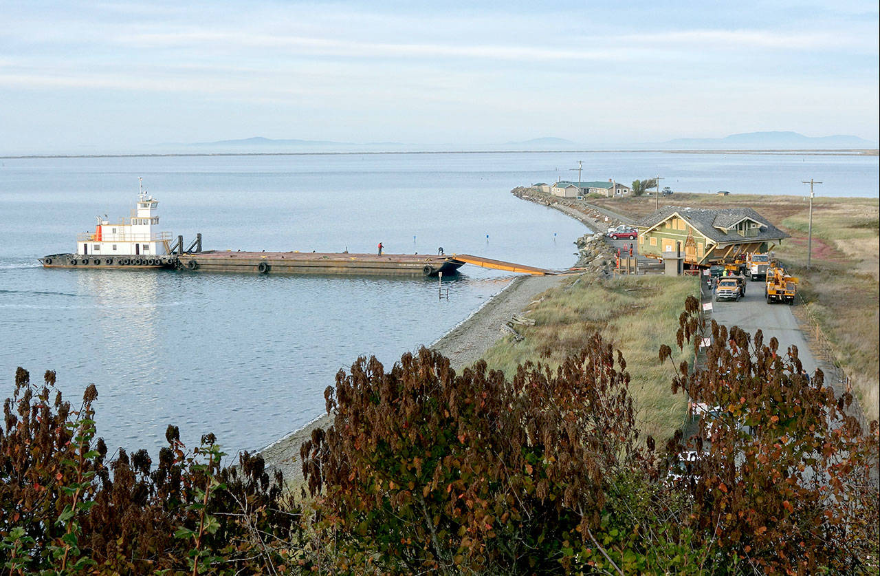 A barge delivered a 1916 Sears kit house to Cline Spit on Monday. Crews from Nickel Bros. helped unload the house, purchased by Jim and Diane Luoma and moved from Shelton. (Steve Jones )