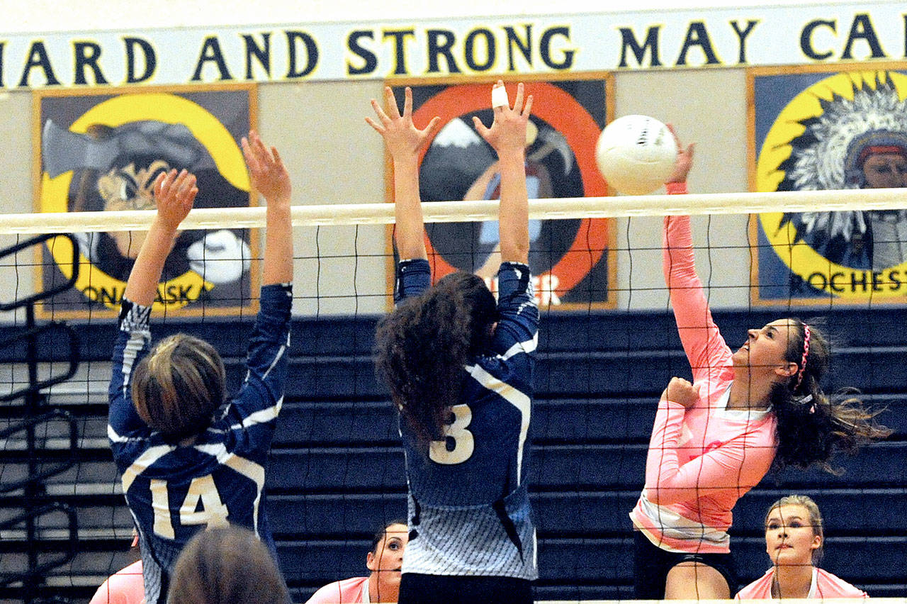 Wearing pink uniforms for breast cancer awareness night Forks’ Britney Dean challenges Elma’s Eden Martin (14) and Maddi Clark (3) at the net during the Spartans’ five-set loss to Elma.                                Lonnie Archibald/for Peninsula Daily News