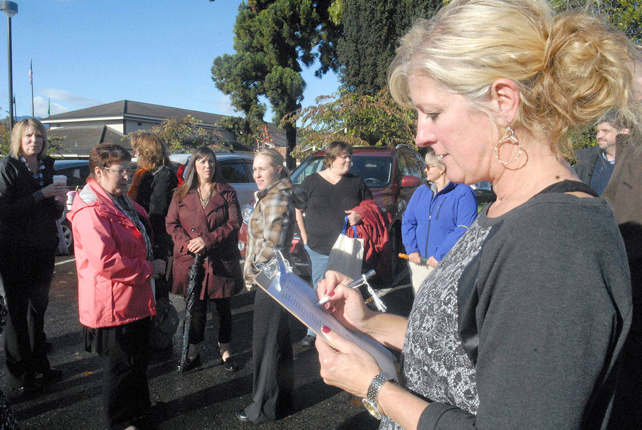 Lacey Fors, Clallam County Superior Court administrator, right, takes a tally of courthouse employees after a mock evacuation of the building as part of the 2016 Great ShakeOut, a global earthquake drill, last year. Employees of the courthouse in Port Angeles gathered at designated points around the courthouse, including the parking lot of Port Angeles City Hall, to simulate procedures laid out in the event of a real earthquake or natural disaster. (Keith Thorpe/Peninsula Daily News)