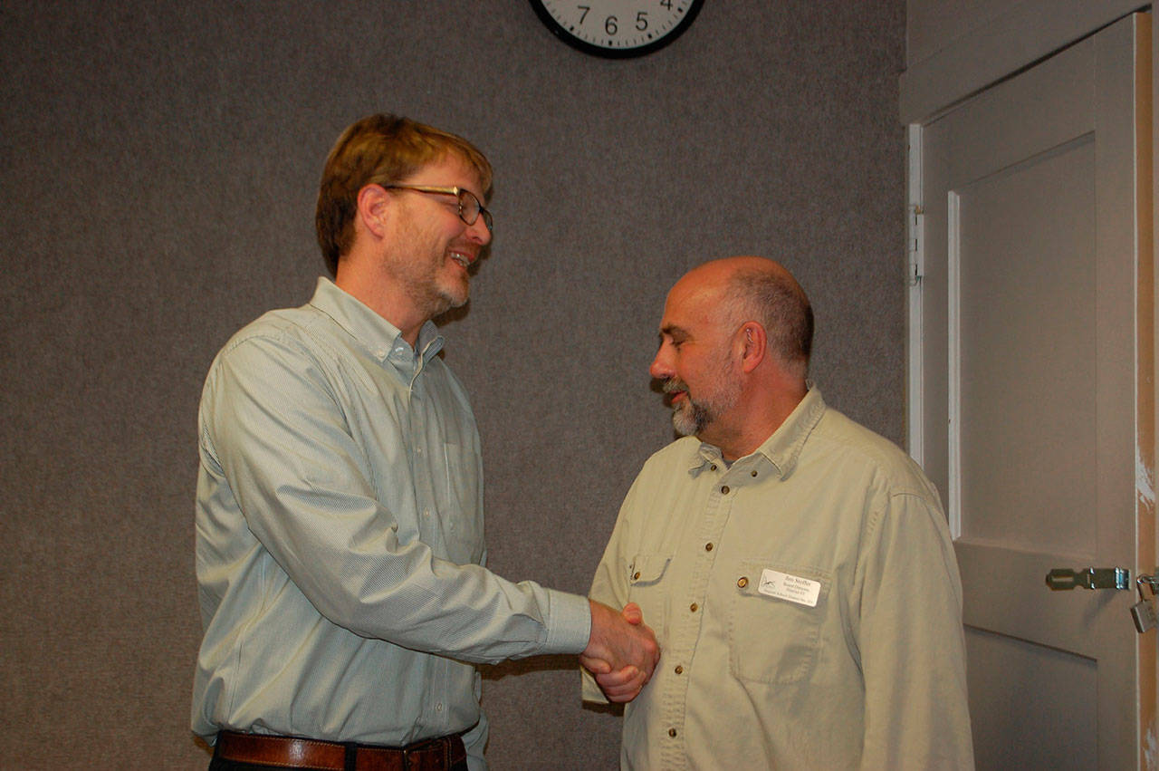 Sequim Education Association member and Sequim High School teacher Jon Eekhoff shakes hands with school board director Jim Stoffer after the board meeting Monday, where the board approved the collective bargaining agreement for Sequim teachers. (Erin Hawkins/Olympic Peninsula News Group)