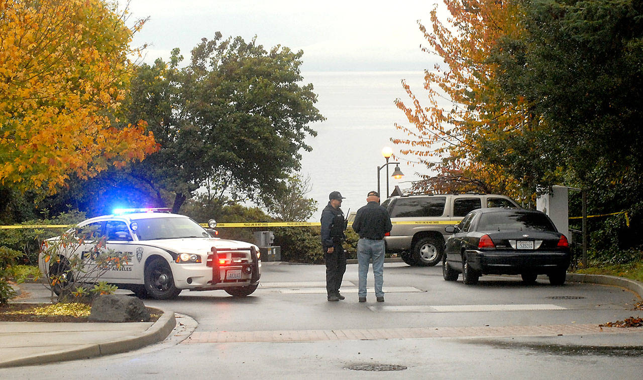 Port Angeles Police Officer T.J. Mueller talks with a passer-by near the scene of where the body of a woman was found on the Olympic Discovery Trail at 9/11 Memorial Waterfront Park on Thursday in Port Angeles. (Keith Thorpe/Peninsula Daily News)