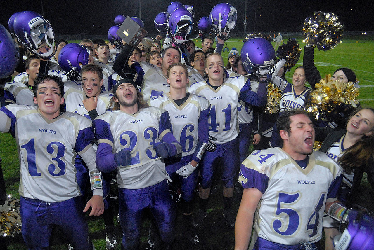 Keith Thorpe/Peninsula Daily News Members of the Sequim Wolves football team celebrate after defeating Port Angeles 29-14 in Friday night’s Rainshadow Rumble at Port Angeles Civic Field. Included at the front of the celebration were, from left, Taig Wiker, Gavin Velarde, Ben Newell, Isaiah Cowan and Adam DeFillipo, front. Holding the trophy was Mason Larsen.
