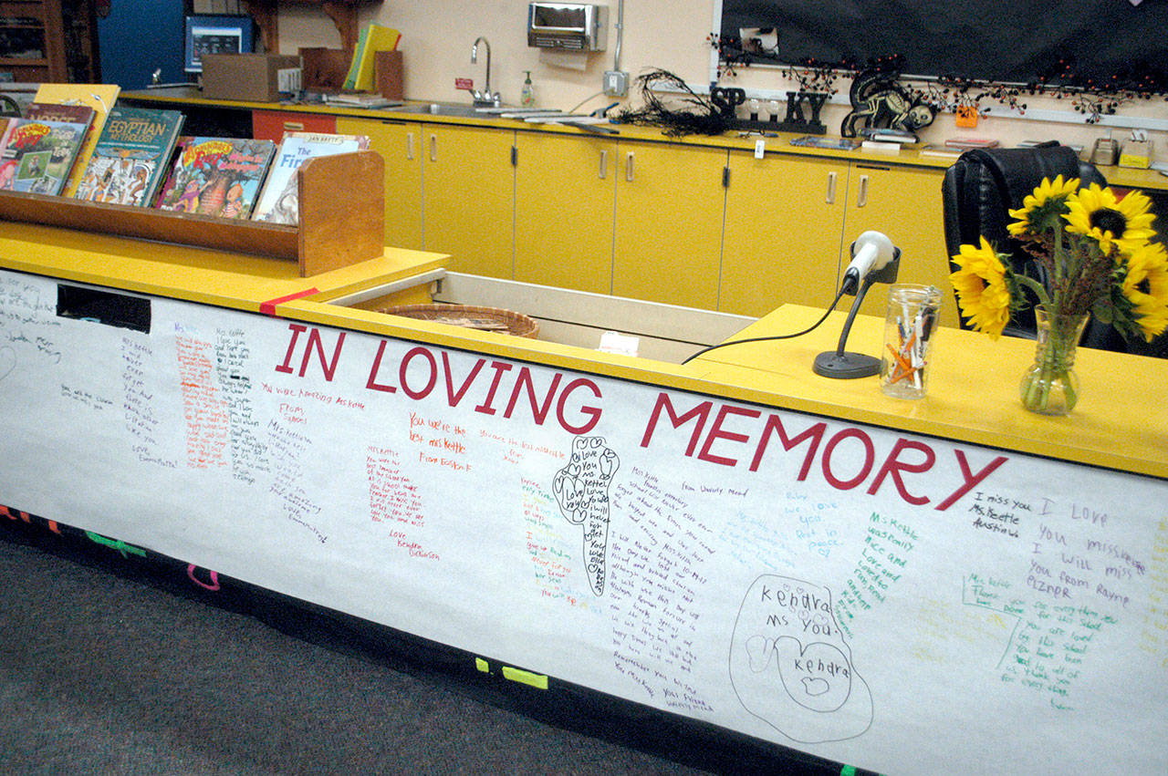 Notes in memory of paraeducator Sheila Kettel span a long desk in Franklin Elementary School’s library, where Kettel spent much of her time. (Sarah Sharp/Peninsula Daily News)