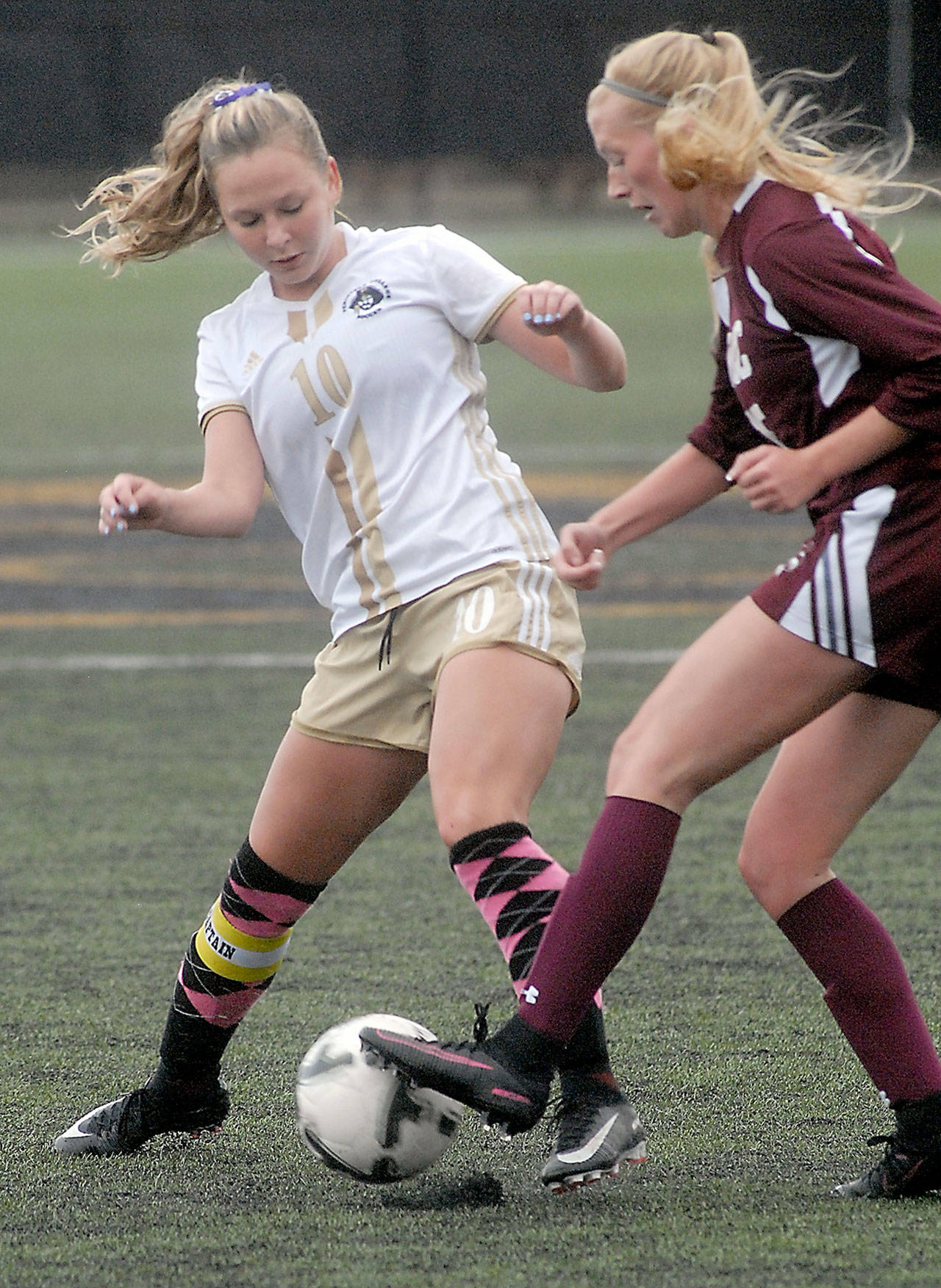 Peninsula’s Kelly Kevershan, left, battles for the ball with Whatcom’s Payton Lunde on Wednesday at Wally Sigmar Field in Port Angeles.                                Keith Thorpe/Peninsula Daily News