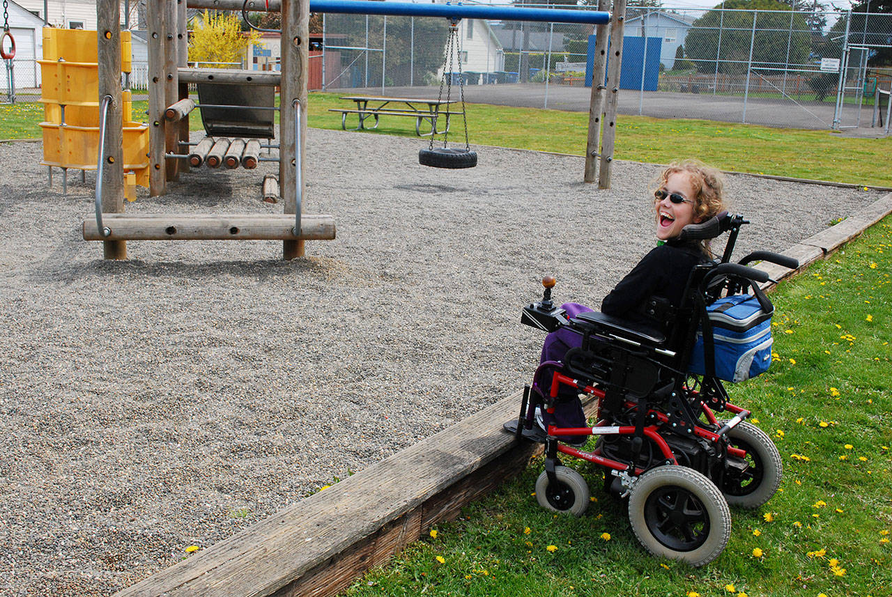 Quinn Redlin Kintner encounters the playground barriers in her power wheelchair at Hazel Porter Kiel Park, 115 W. 13th St. (Kelsey Redlin)