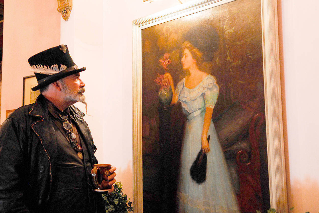 Haunted Historian Jeff Gardner (aka Grymm Depp) studies a painting at the Palace Hotel. He believes she might be one of the ladies who worked there long ago. (Jeannie McMacken/for Peninsula Daily News)