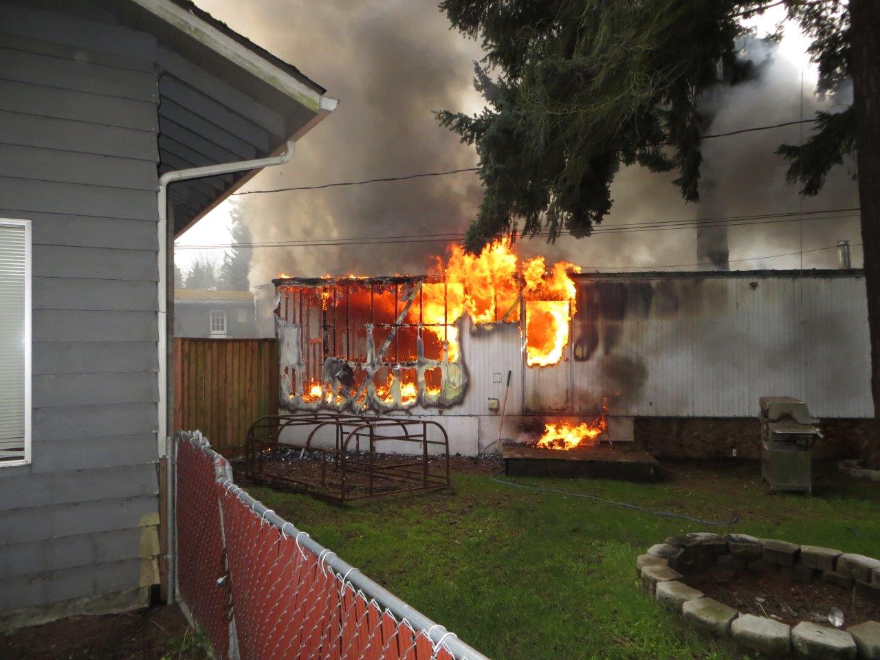 The mobile home in flames before firefighters arrive this afternoon. (Douglas Atterbury)