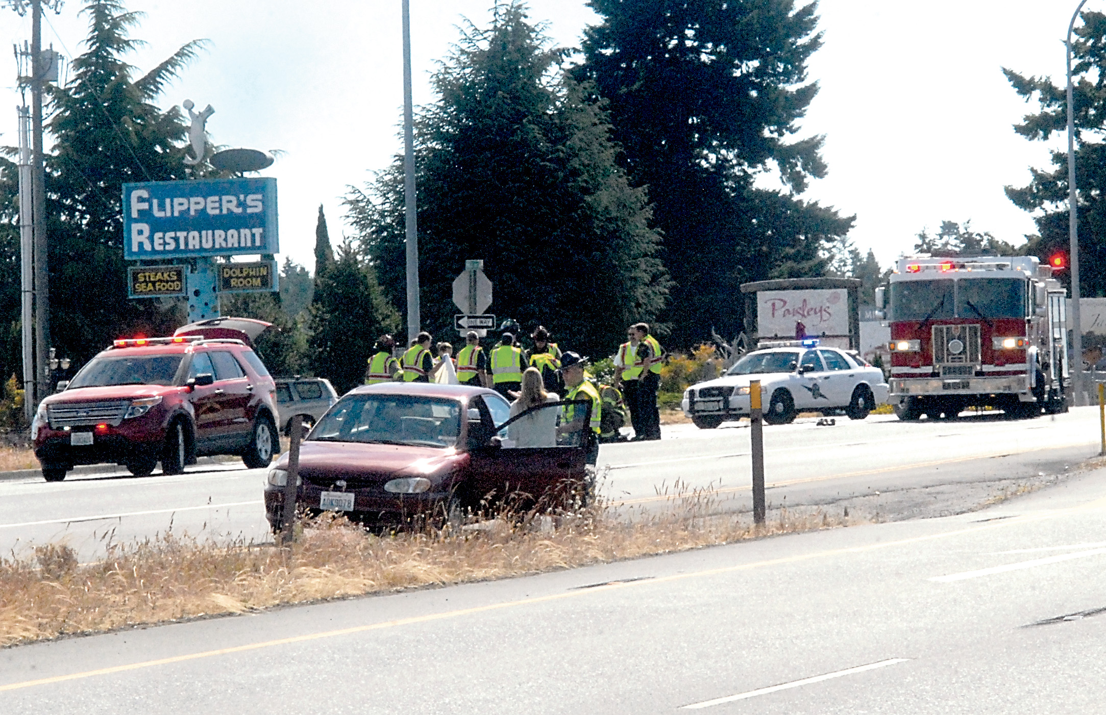 Emergency personnel gather at the scene where a pedestrian was struck and killed on westbound U.S. Highway 101 at Mill Road in Carlsborg on Thursday. (Keith Thorpe/Peninsula Daily News)
