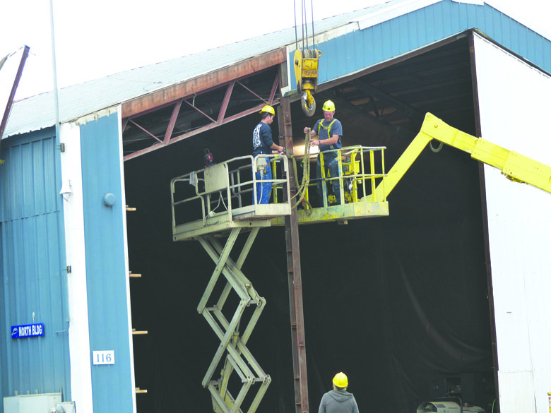 Platypus personnel remove a door on the North Building of Platypus' compound on Marine Drive in Port Angeles to allow ingress and egress of Navy barges. David Sellars/for Peninsula Daily News