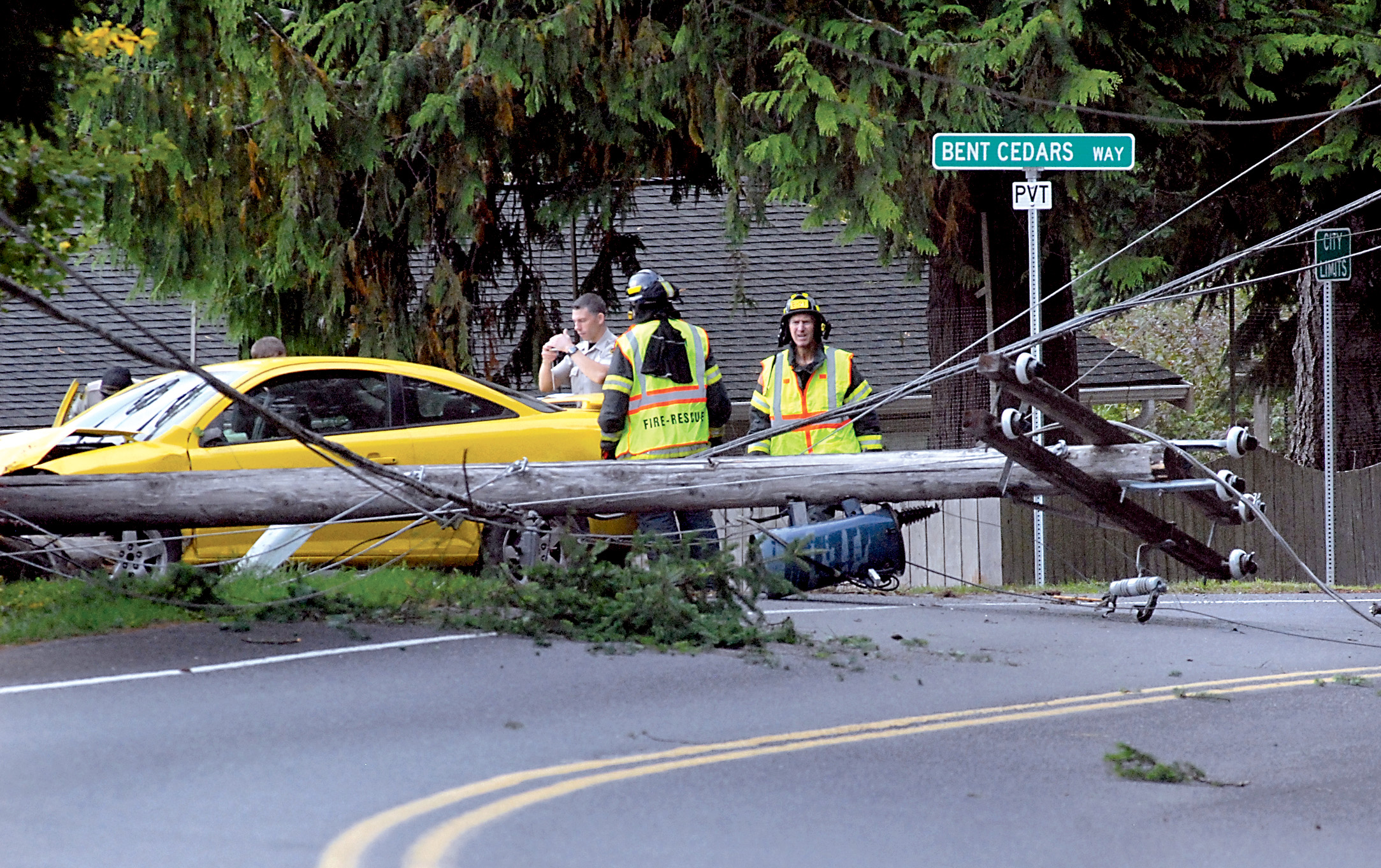 Clallam County Sheriff's deputies and rescue workers from Clallam County Fire District No. 2 investigate the scene where a car struck a utility pole on Mount Angeles Road at Bent Cedars Way near the south edge of Port Angeles today. Keith Thorpe/Peninsula Daily News