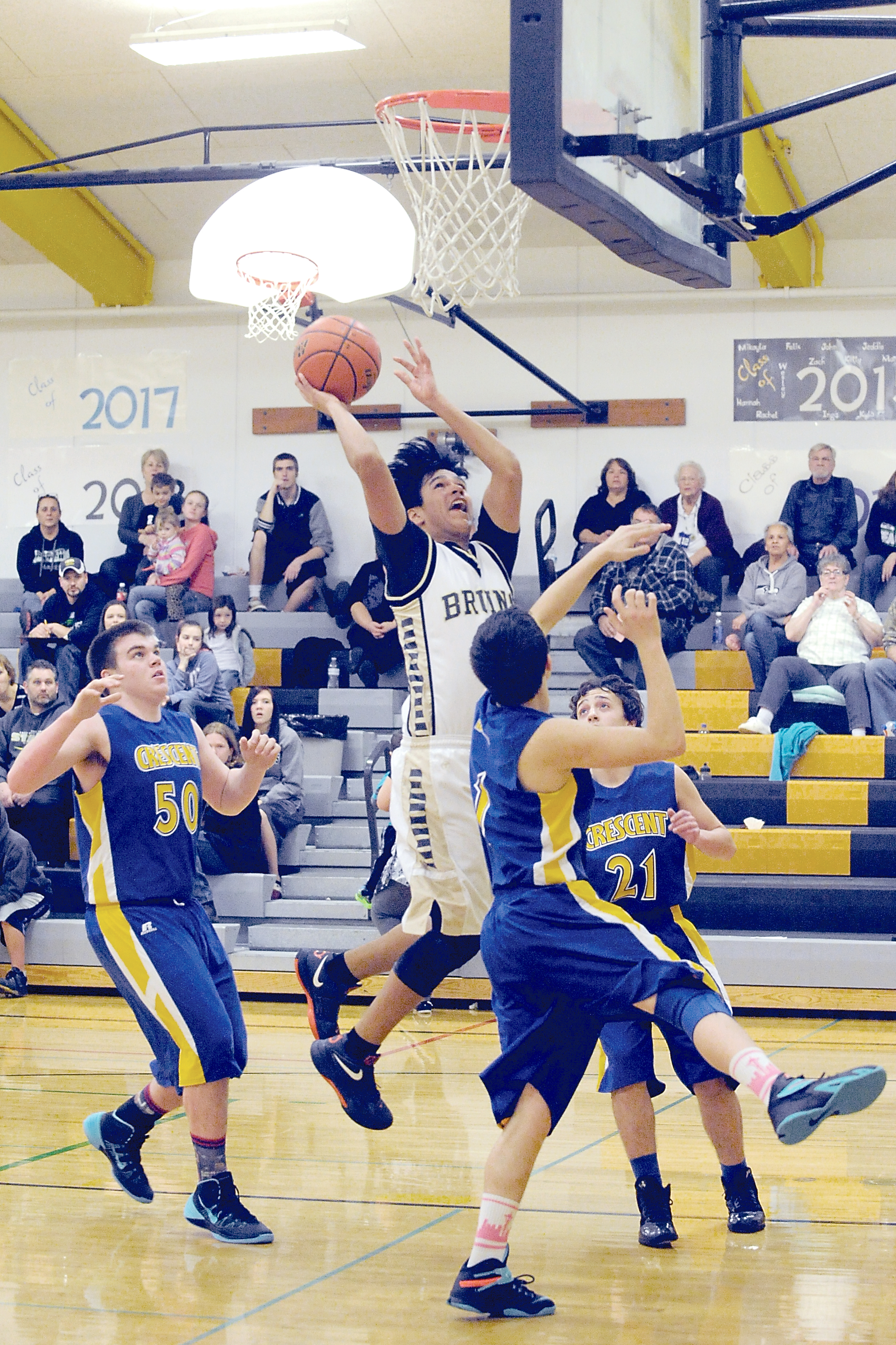 Clallam Bay's Alan Greene (with ball) puts up a shot against Crescent's Neil Peppard (50)