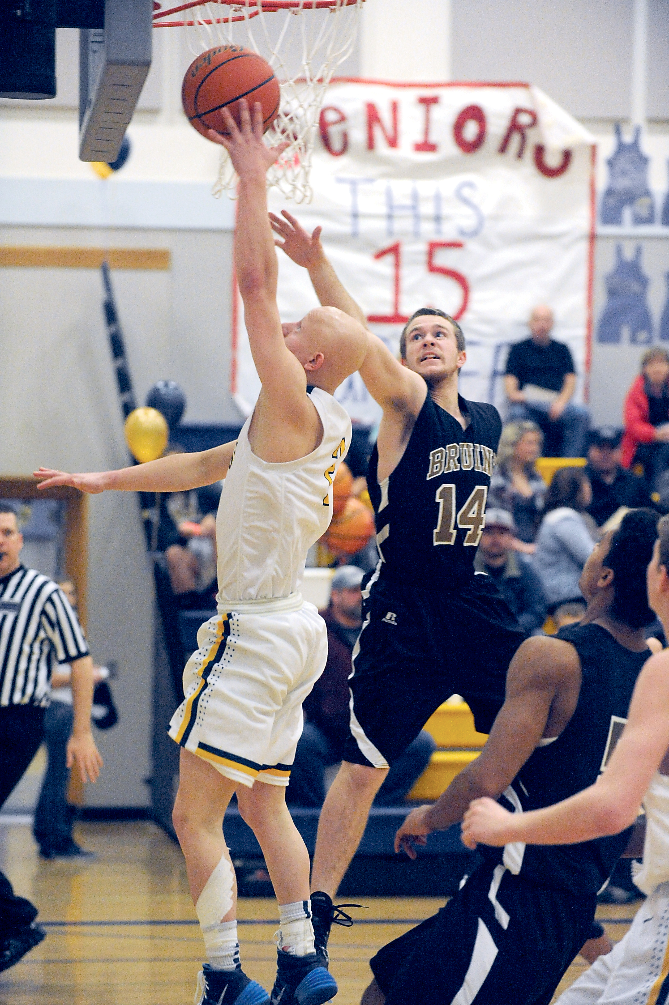 Forks' Colton Raben scores two of his game-high 38 points despite the defense of Clallam Bay's Kyle Keys (14) during the Spartans' 75-50 win Monday in Forks. (Lonnie Archibald/for Peninsula Daily News)