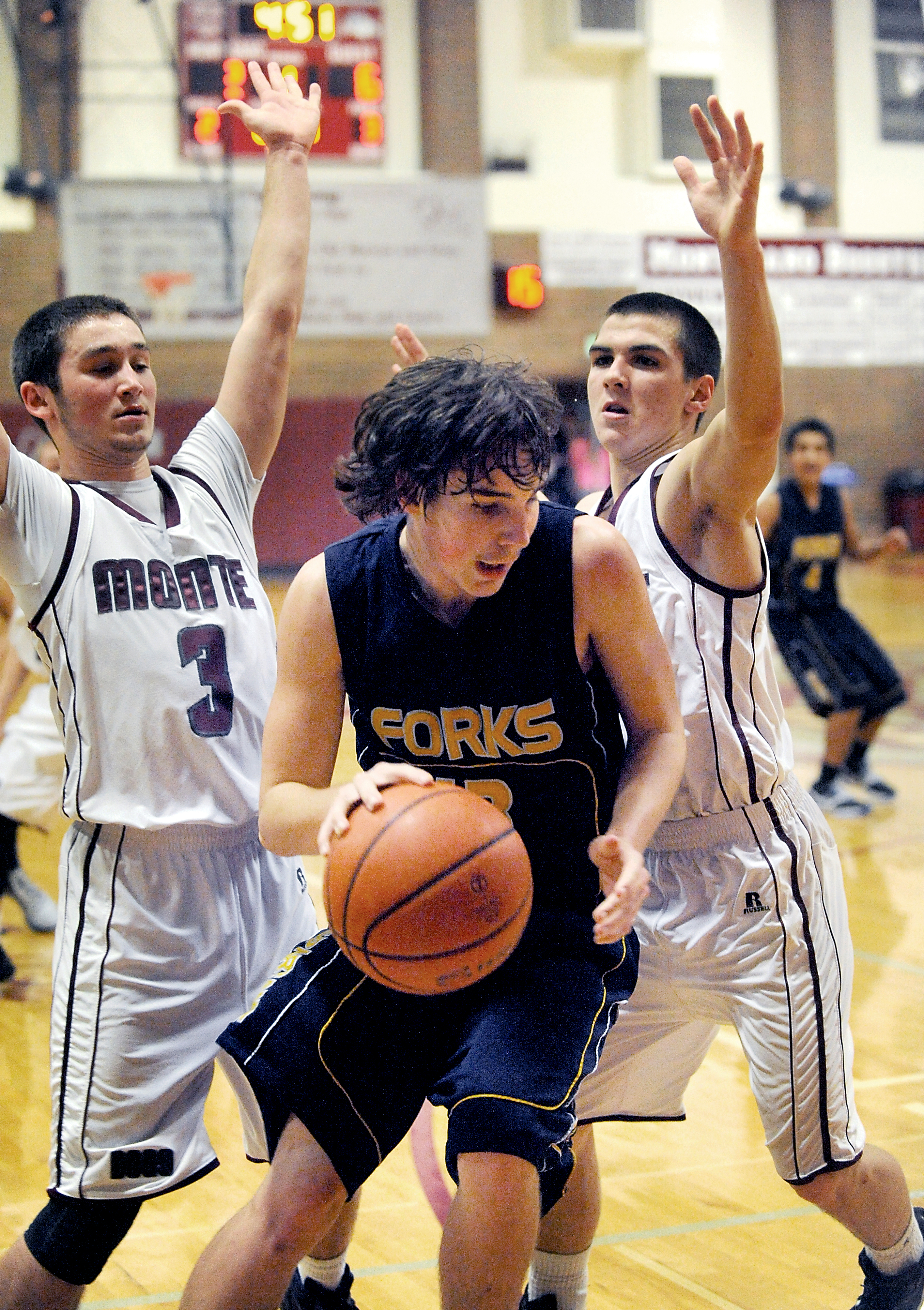 Forks' Billy Palmer looks for an escape route against a pair of Montesano defenders. (Lonnie Archibald/for Peninsula Daily News)