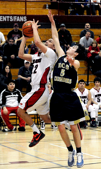 Neah Bay's Kenrick Doherty Jr. rises for a layup against Riverside Christian's Michael Catton during the Red Devils' regional victory last week. (Lonnie Archibald/for Peninsula Daily News)