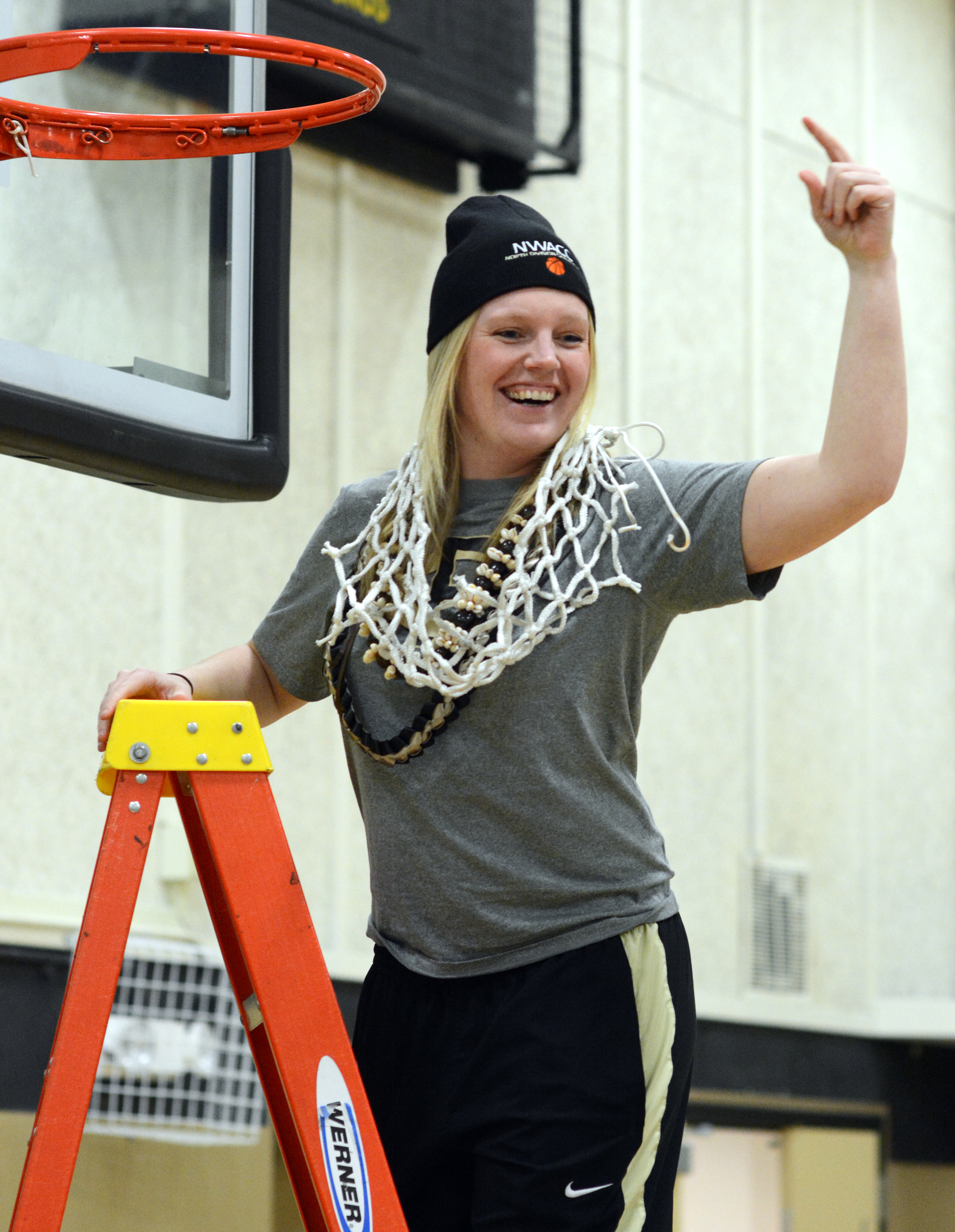 Peninsula College coach Alison Crumb celebrates after cutting down the net after the Pirates won the NWAC North Region championship. (Rick Ross)