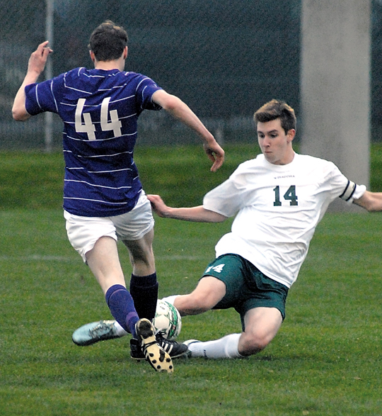 Port Angeles' Scott Methner slides in to block North Kitsap's Clayton Bond in the first half of the Roughriders' victory at Civic Field. (Keith Thorpe/Peninsula Daily News)