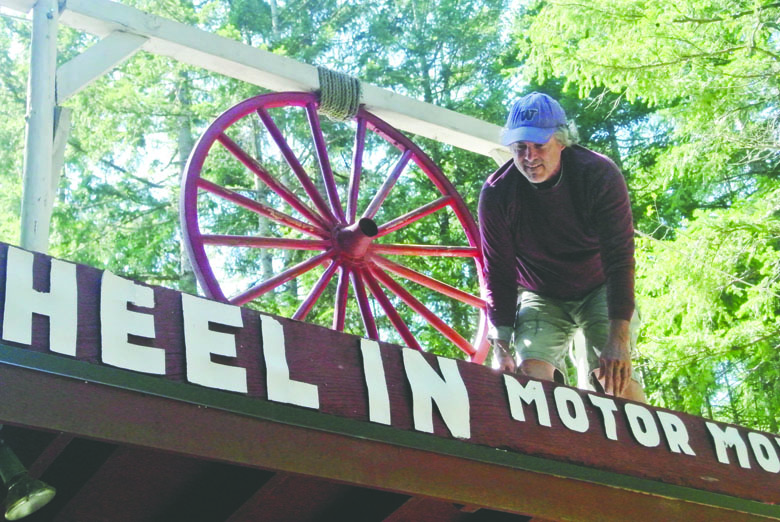 Rick Wiley hangs the sign in 2013 for the Wheel-In Motor Movie in Port Townsend