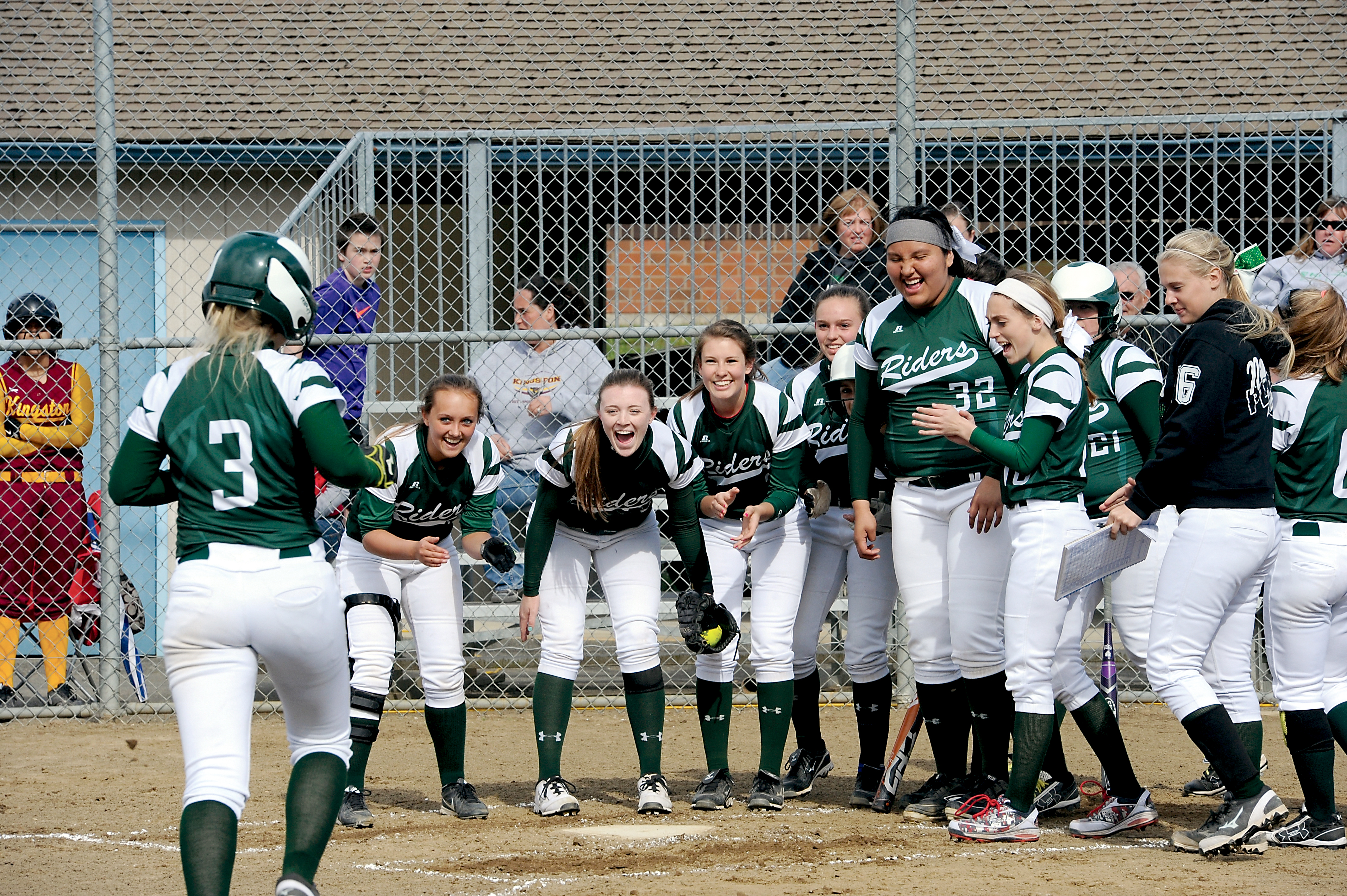 The Port Angeles Roughriders gather at home plate to congratulate Natalie Steinman (3) after hitting the first of her two home runs against Kingston. (Lonnie Archibald/for Peninsula Daily News)