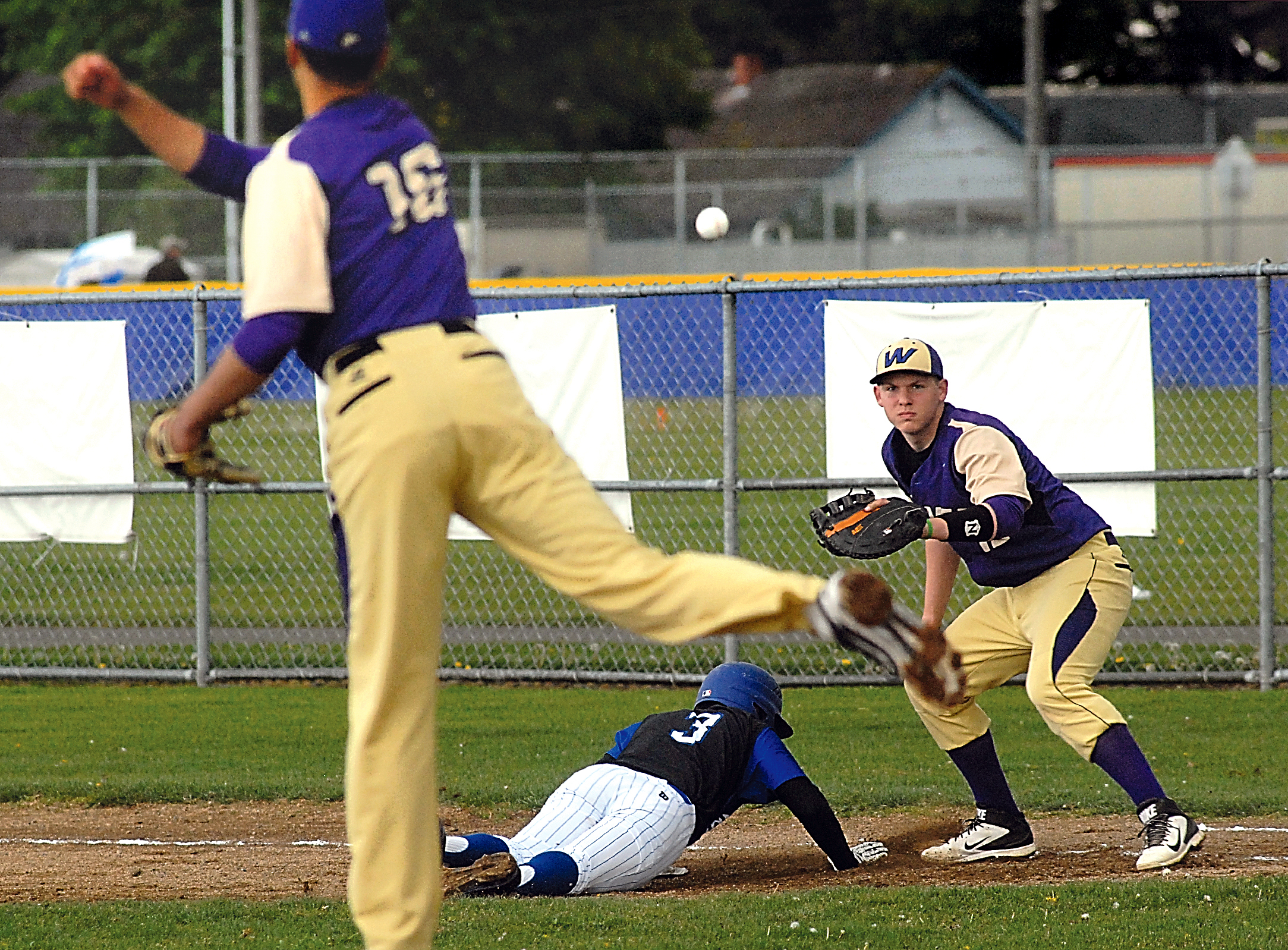 Sequim pitcher Nigel Christian (16) throws to first baseman Daniel Harker in an attempt to pick off North Mason's D'Ante Long. (Keith Thorpe/Peninsula Daily News)