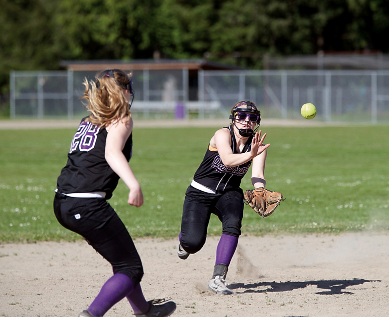 Quilcene's Megan Weller makes a play on the ball while younger sister Abby Weller looks on during the Rangers' 18-7 win over Rainier Christian. (Steve Mullensky/for Peninsula Daily News)