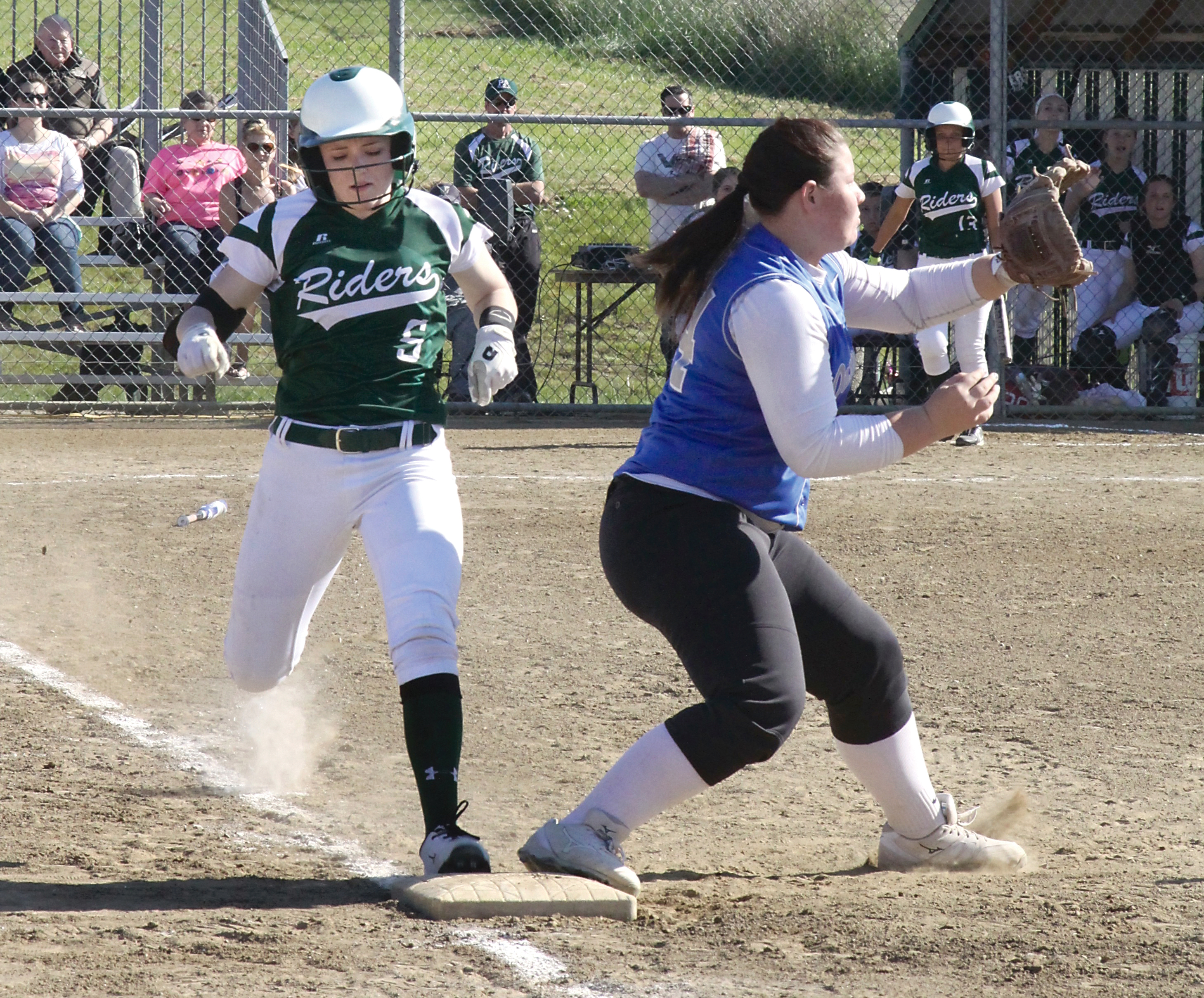 Port Angeles' Carly Gouge steps on first base before the ball reaches Olympic first baseman Sage Scott. (Dave Logan/for Peninsula Daily News)