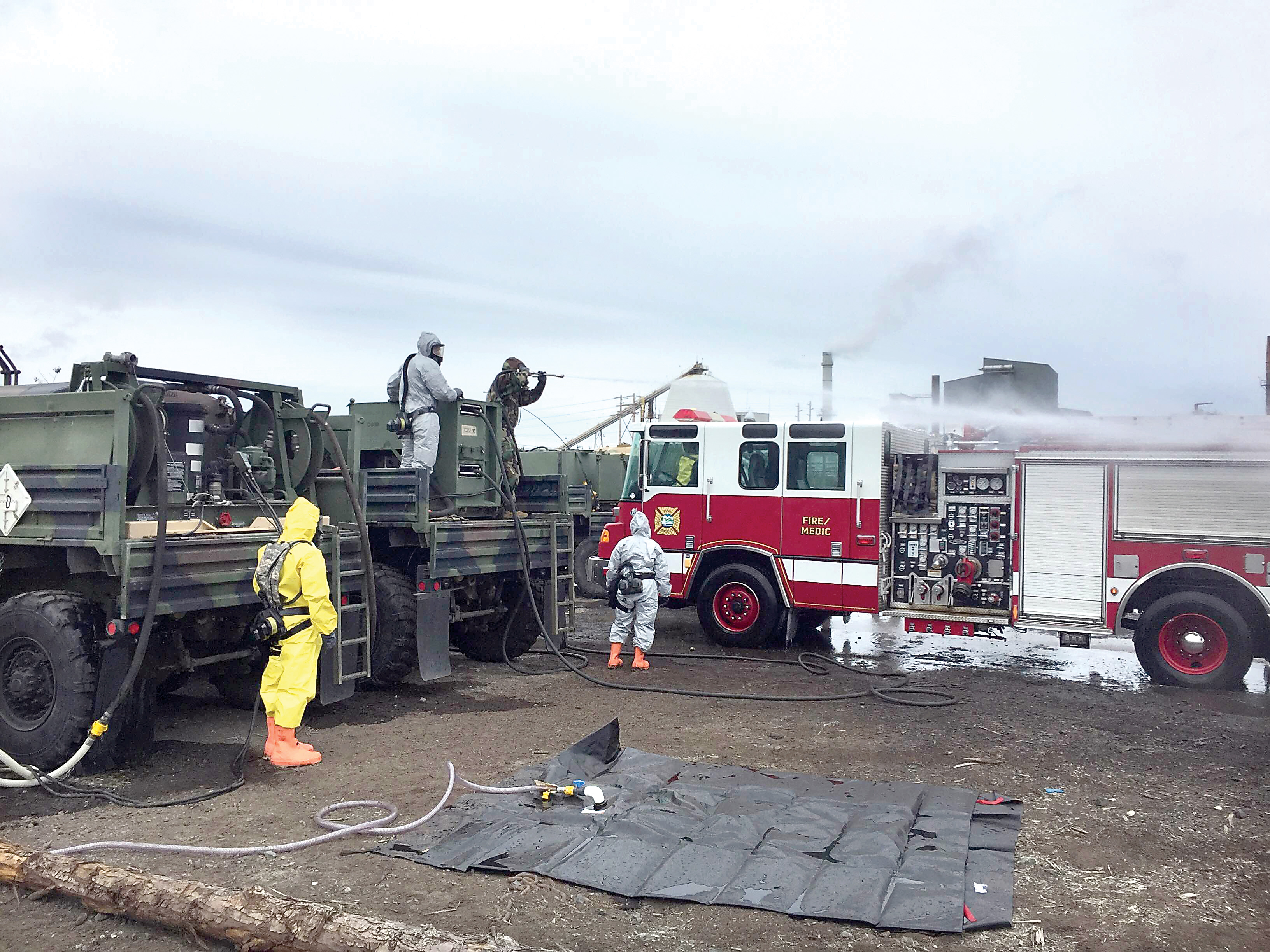 Washington National Guard personnel hose down a fire truck that could be contaminated with various wastes in the event of a tsunami during the Cascadia Rising drill. (Washington National Guard)