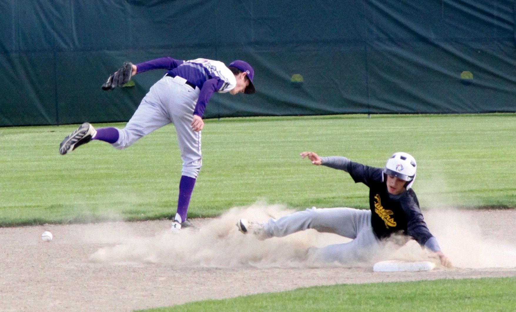 Ben Bruner of the Olympic Crosscutters slides safely into second base as the ball trickles away form North Kitsap shortstop Tyler Meck. (Dave Logan/for Peninsula Daily News)