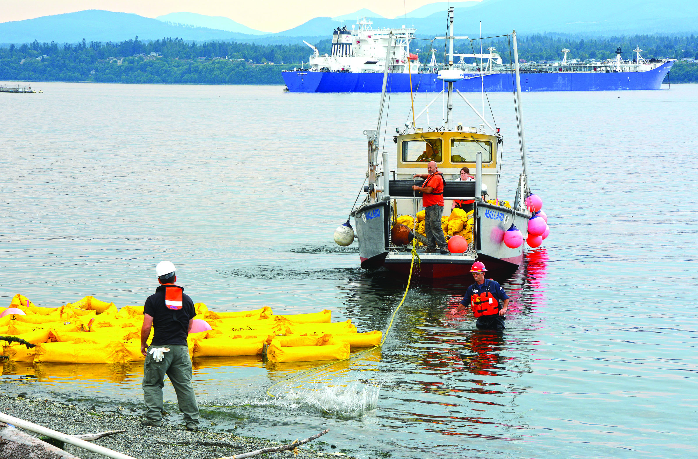 Participants work together Wednesday as part of the Pacific Northwest Oil Spill Control Course in Port Angeles Harbor. Jay Cline