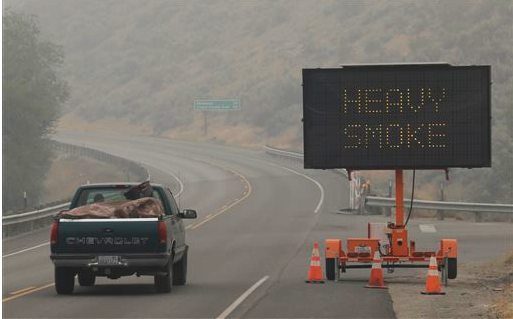 A sign warns of "Heavy Smoke" on Washington state Highway 155 near Omak on Wednesday (Aug. 26). Wildfires in the area have generated heavy smoke that has slowed traffic and in some instances hindered efforts to fight the fires from the air. The Associated Press