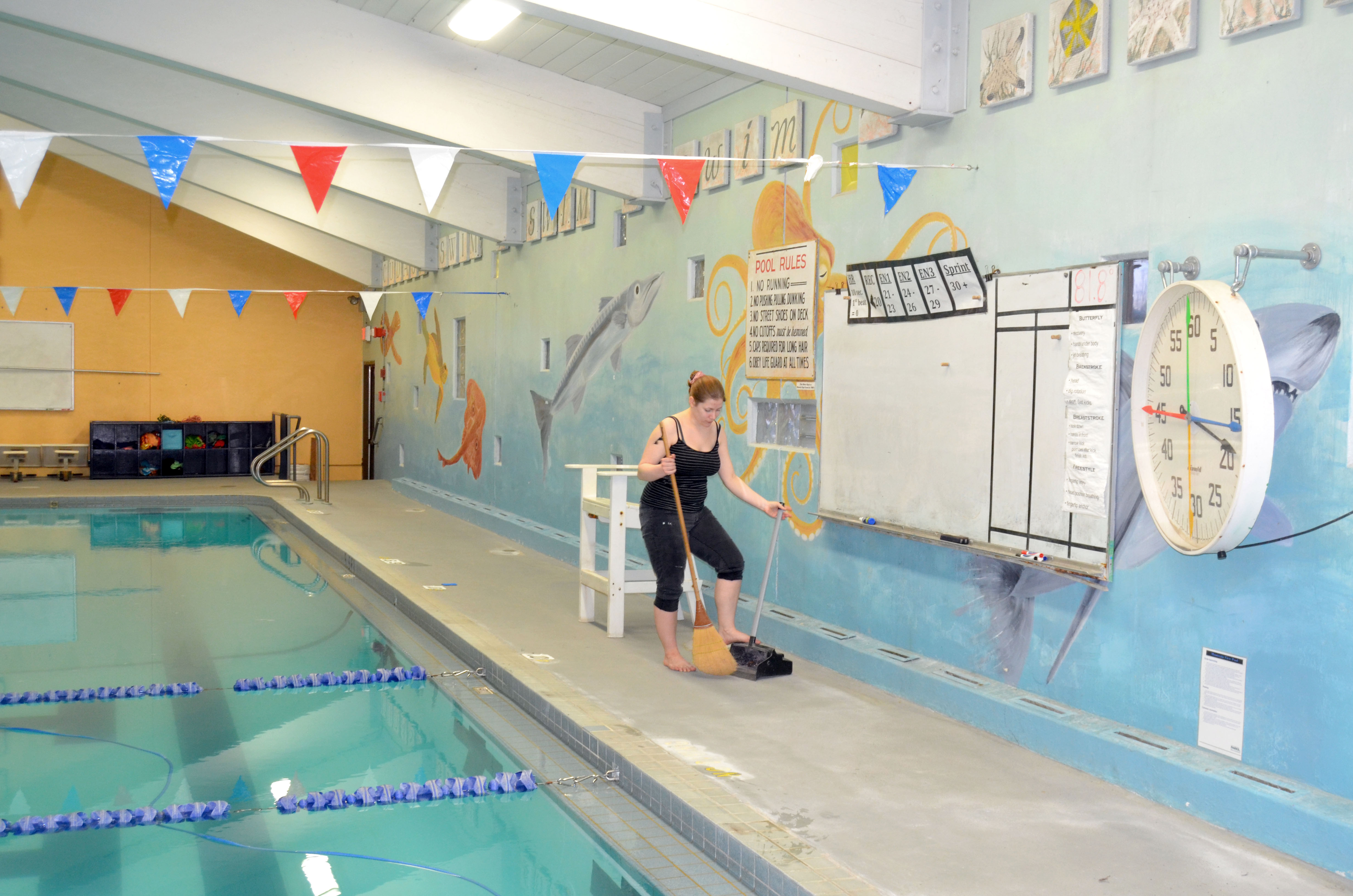 Mountain View Pool employee Sammi Quayle cleans the sides of the pool in preparation for its reopening today. —Photo by Charlie Bermant/Peninsula Daily News ()
