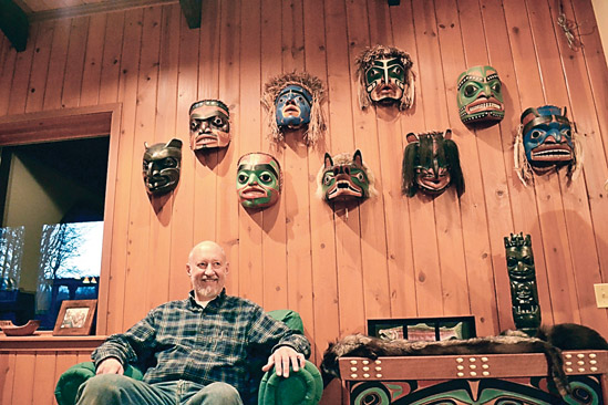 Master Carver Dale Faulstich sits with handcrafted masks in his living room shortly before his retirement from full-time carving. For 20-plus years
