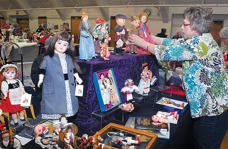Judy Lofall of Poulsbo-based Lofalls Dolls arranges a display table filled with dolls and accessories during Promise of Spring Doll Show at Vern Burton Community Center in Port Angeles in 2014. The event