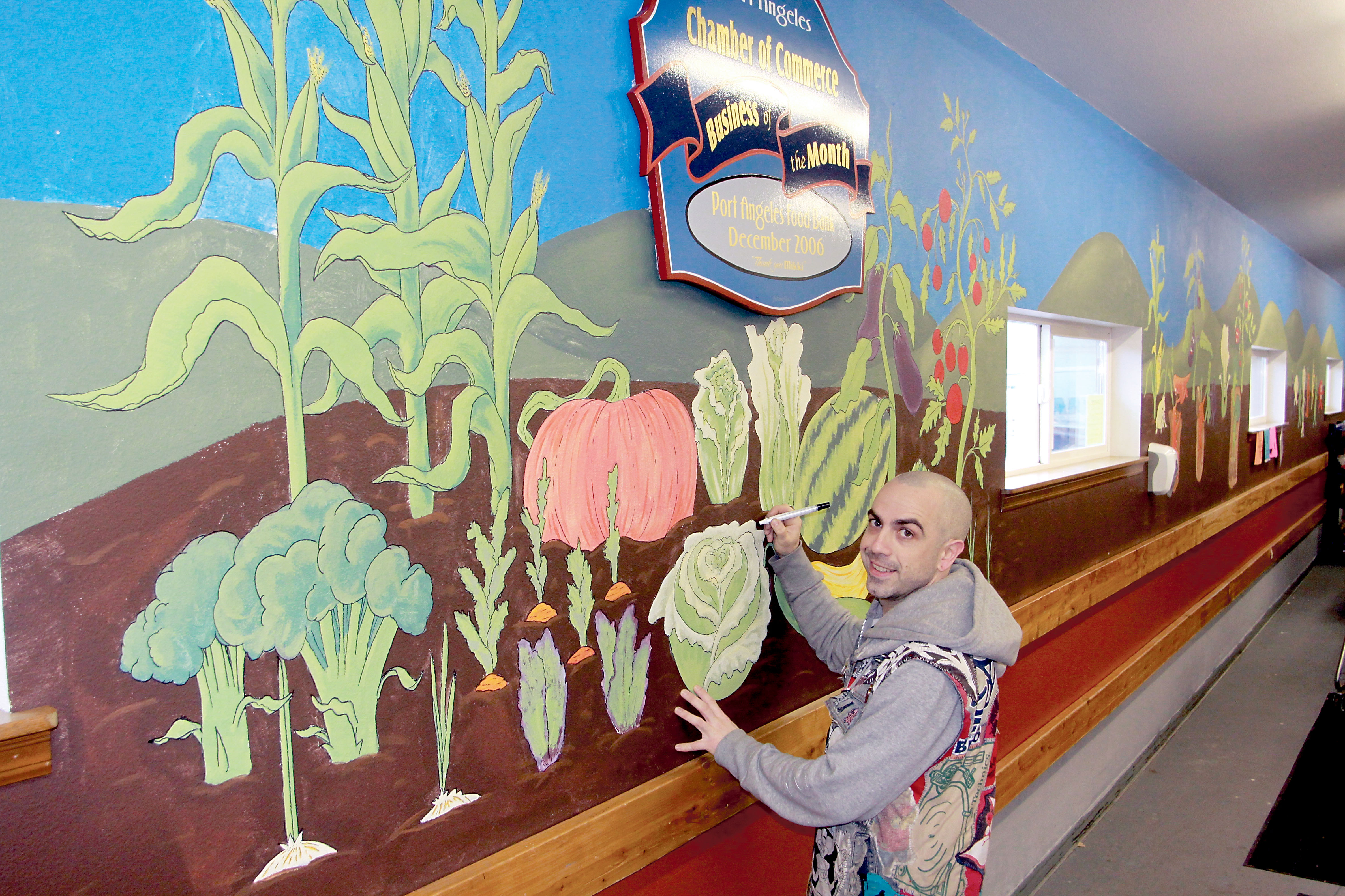 Jimbo Cutler works Tuesday on the new mural inside the Port Angeles Food Bank.  Dave Logan/for Peninsula Daily News ()